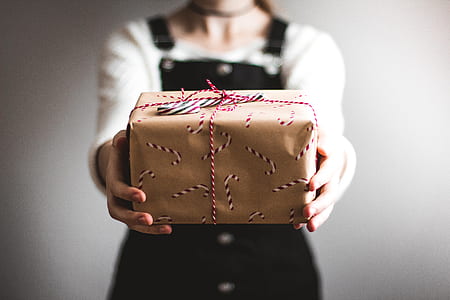 shallow focus photography of a person holding gift box thumbnail