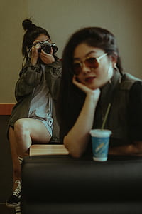 woman holding black DSLR camera thumbnail