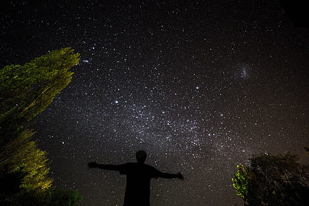man raising his hands towards the night sky thumbnail