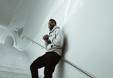 man leaning on white wall thumbnail