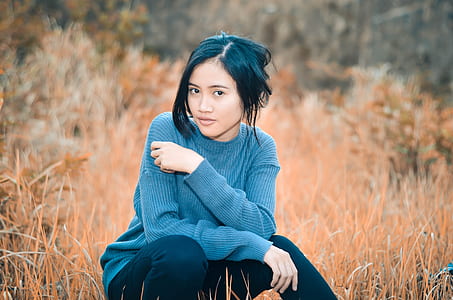 selective focus photography of woman sitting on grass field thumbnail