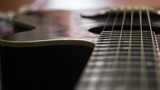 shallow focus photography of brown and black acoustic guitar thumbnail