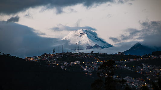 photo of houses and glacier mountain under cloudy sky thumbnail