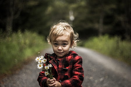 shallow focus photography of girl holding a bouquet of flowers thumbnail