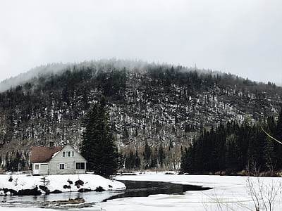 house near body of water and mountain thumbnail