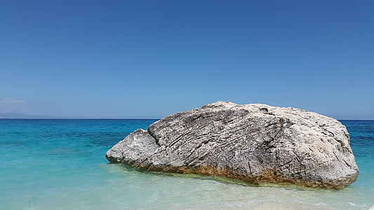 grey rock on blue water landscape photography at daytime thumbnail
