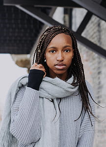 woman with braided hair standing under black awning during daytime thumbnail