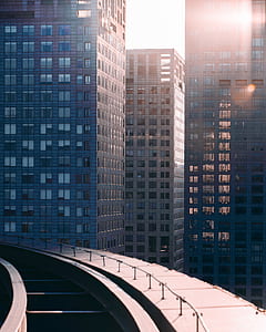 three curtain wall buildings near concrete pathway at daytime thumbnail