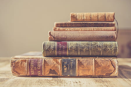 selective focus photography of pile of hardbound books thumbnail