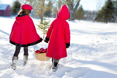 two toddler wearing red robe while walking on white snow covered ground thumbnail