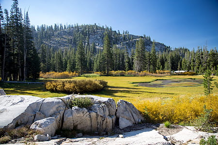 rock formation in front of green fields during daytime thumbnail