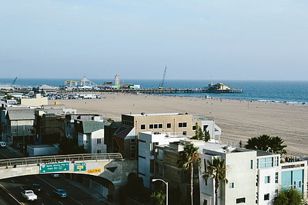 photo of white concrete buildings near sea at daytime thumbnail