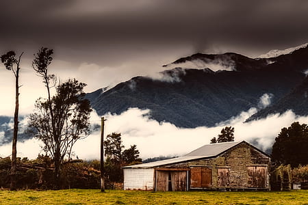 house near mountain under gray sky thumbnail