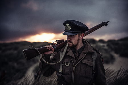 Close-Up Photography of a Man Holding Rifle thumbnail