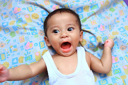 baby in white tank top with open mouth thumbnail
