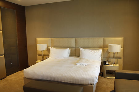 white bedspread and pillows on bed inside room thumbnail