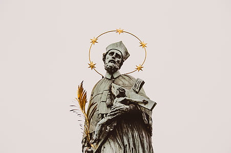 statue of man holding crucifix of Jesus Christ thumbnail