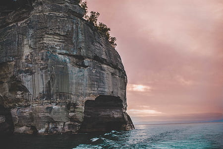 rock formation next to body of water during golden time thumbnail
