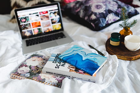 Bed full of pillows and notebooks with Apple gadgets thumbnail