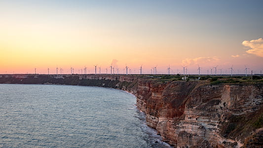 windmills near body of water thumbnail