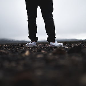 shallow focus photograph of person wearing black pants and white sneakers thumbnail