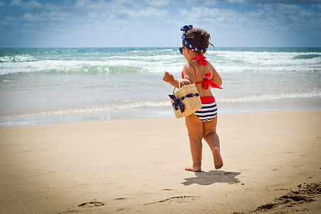 toddler girl near body of water during daytime thumbnail