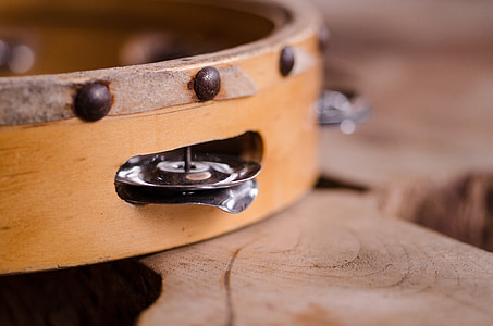 closeup of brown tambourine on wood slab thumbnail