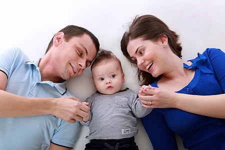 baby between man and woman holding their hands thumbnail