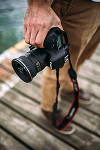 Photographer holding a DSLR camera thumbnail