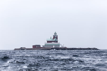 red and white lighthouse near body of water during daytime thumbnail