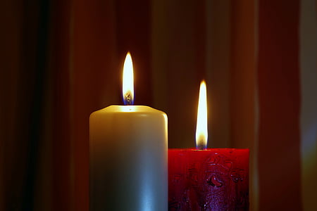 two lighted brown and red pillar candles thumbnail