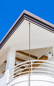 white concrete house with brown metal chain hangs on ceiling thumbnail