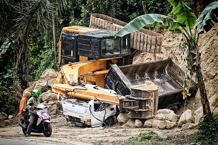 gray motor scooter across wrecked trucks thumbnail