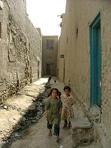 two girls standing between buildings during daytime thumbnail