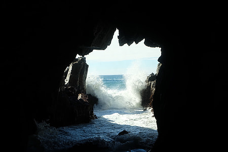 gray cave with beach waves at daytime thumbnail