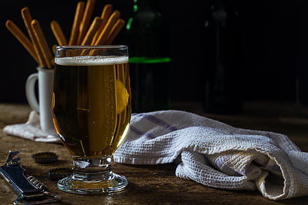 clear goblet glass beside white towel on brown wood thumbnail