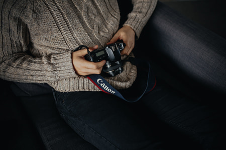 person holding Canon DSLR camera thumbnail