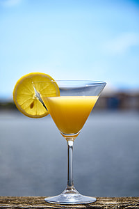yellow liquid inside martini glass with slice of lemon thumbnail
