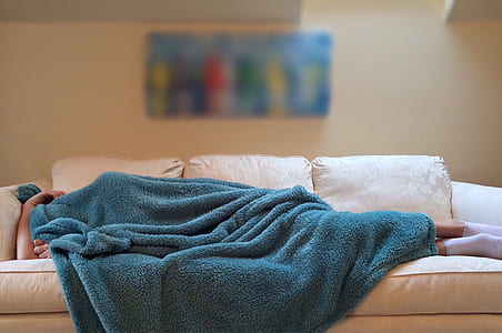 person lying on sofa covering body thumbnail