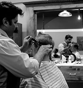 grayscale photography of man holding scissor thumbnail