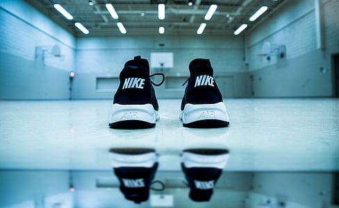 pair of white-and-black Nike Air low-top sneakers on white floor surface thumbnail
