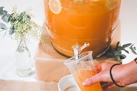 person pouring lemon drink in plastic cup thumbnail