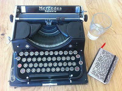 blue and black Mercedes typewriter on brown wooden table thumbnail