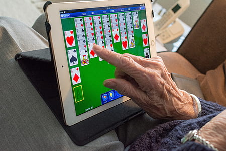 person playing solitaire on white iPad thumbnail