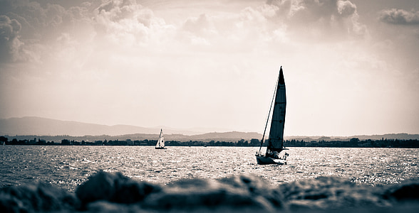 grayscale photo of sailboat on body of water thumbnail