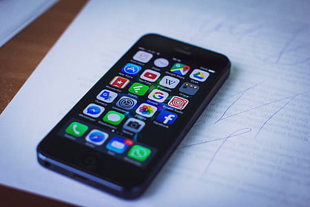 turned-on black iPhone 5 on top of white printer paper thumbnail
