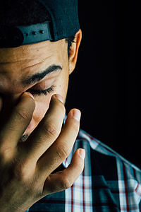 close up photo of man wearing cap and top while touching his left eye thumbnail