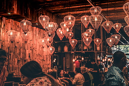 hanging light with people sitting on chair talking each other inside the restaurant thumbnail