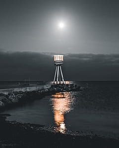 selective photo of lighthouse beside sea thumbnail