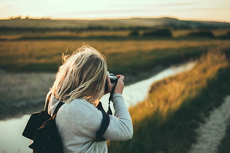 woman taking photo of grass field thumbnail